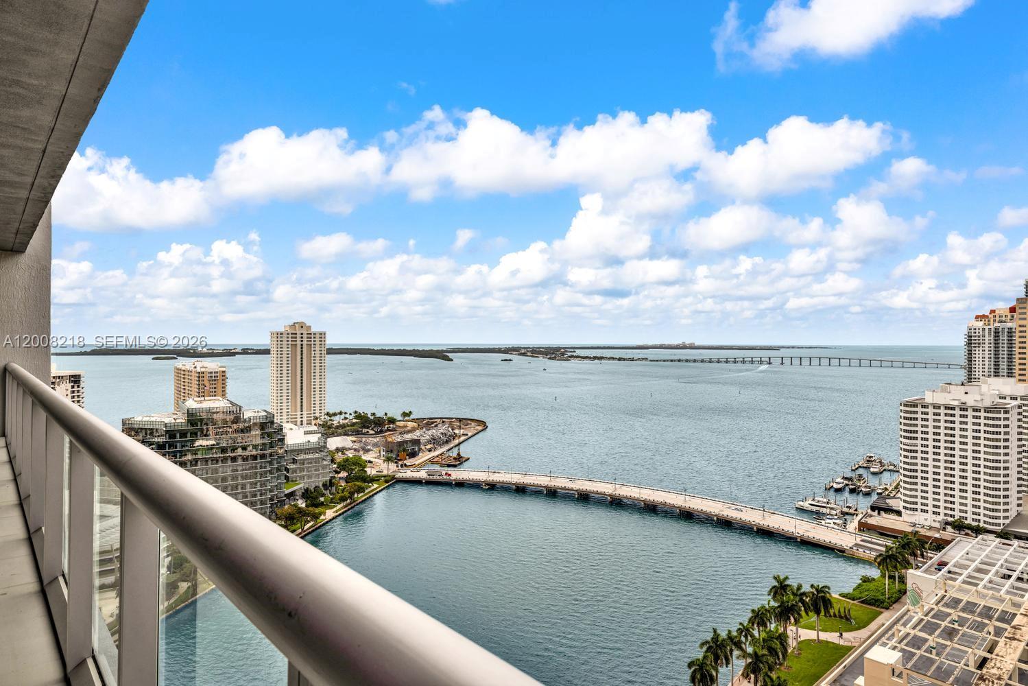 A high-angle view from a balcony overlooking a bay, a bridge, and city buildings — 495 Brickell Ave # 2603, Miami FL 33131, MIAMI, FL