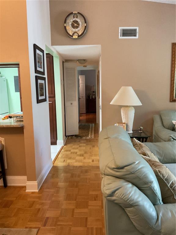 A view from a living room looking down a hallway with parquet flooring — 2655 PINE RIDGE WAY N UNIT D3, PALM HARBOR, FL