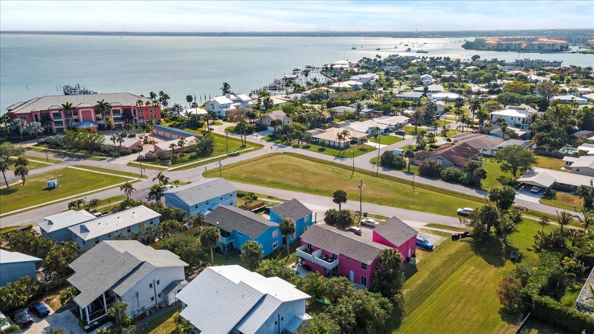 An aerial view shows a coastal neighborhood with colorful houses, green lawns, and a bay — 646 Eldorado Street, Fort Pierce FL 34949, FORT PIERCE, FL