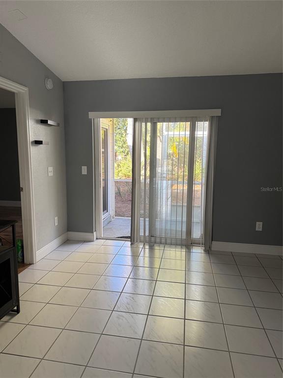 A room with light-colored tile flooring, gray walls, and a sliding glass door to a patio — 3321 ROYAL STREET, WINTER PARK, FL