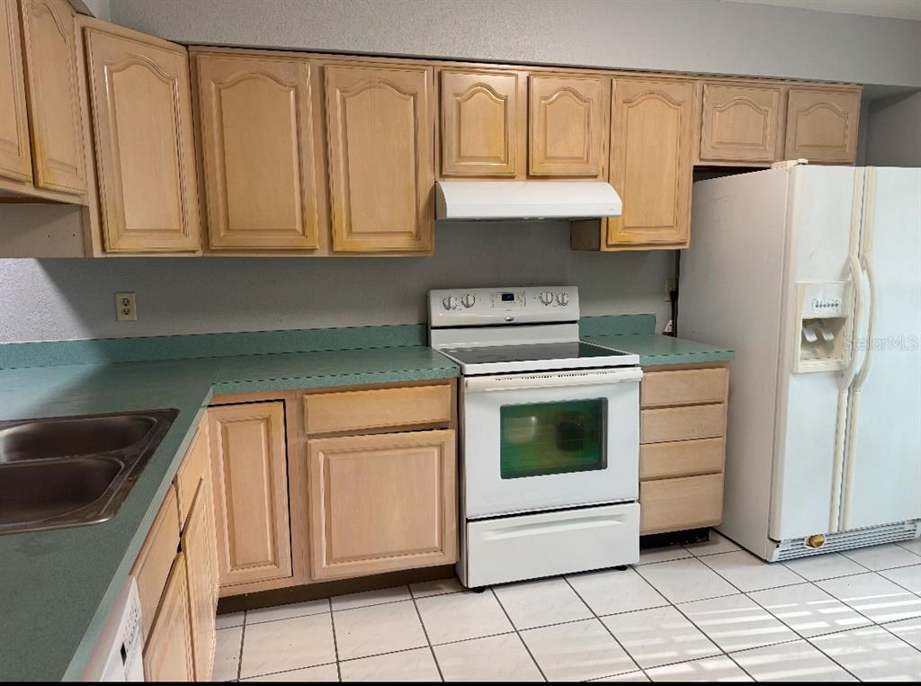A kitchen features light wood cabinets, teal laminate countertops, white appliances, and white floor tiles — 3321 ROYAL STREET, WINTER PARK, FL