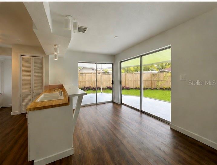 A kitchen with a wood countertop island overlooks a backyard through large sliding glass doors — 12620 82ND TERRACE, SEMINOLE, FL
