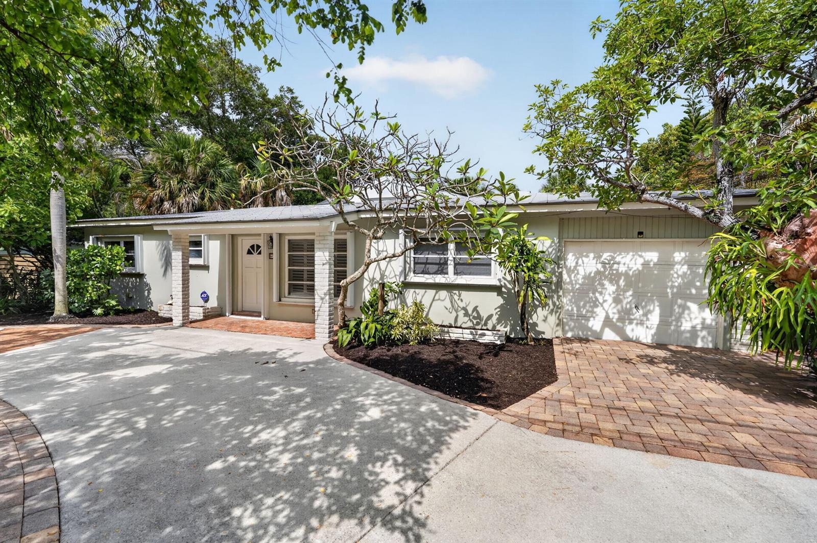 A single-story house with a white garage, light-colored exterior, and a paved driveway — 606 Paulina Road, Jupiter FL 33477, JUPITER, FL