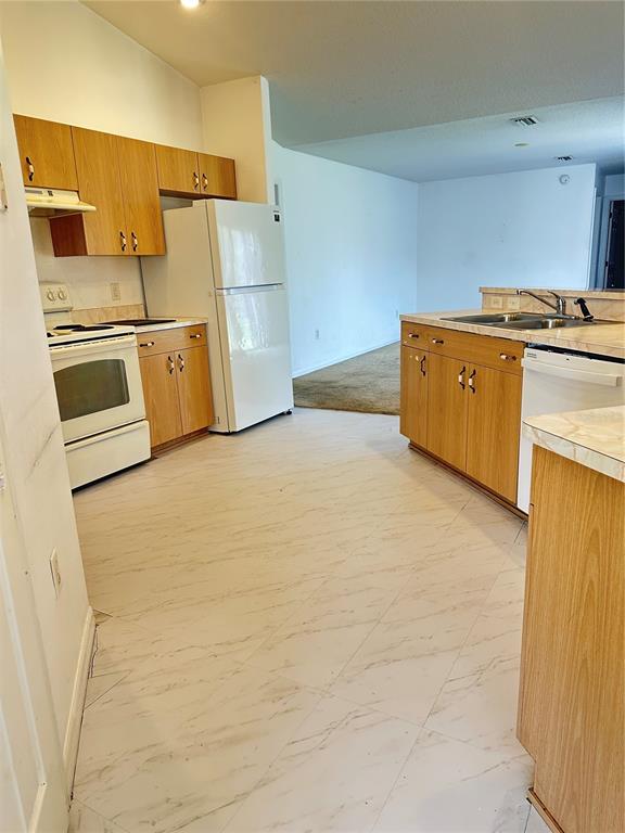 A kitchen with light wood cabinets, white appliances, and white marble-patterned tile flooring — 13540 SW 86TH AVENUE, OCALA, FL