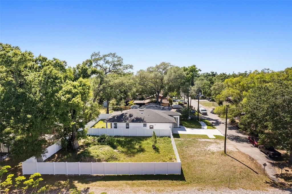 An aerial view shows a white house with a dark roof enclosed by a white fence — 2617 E PALIFOX STREET, TAMPA, FL