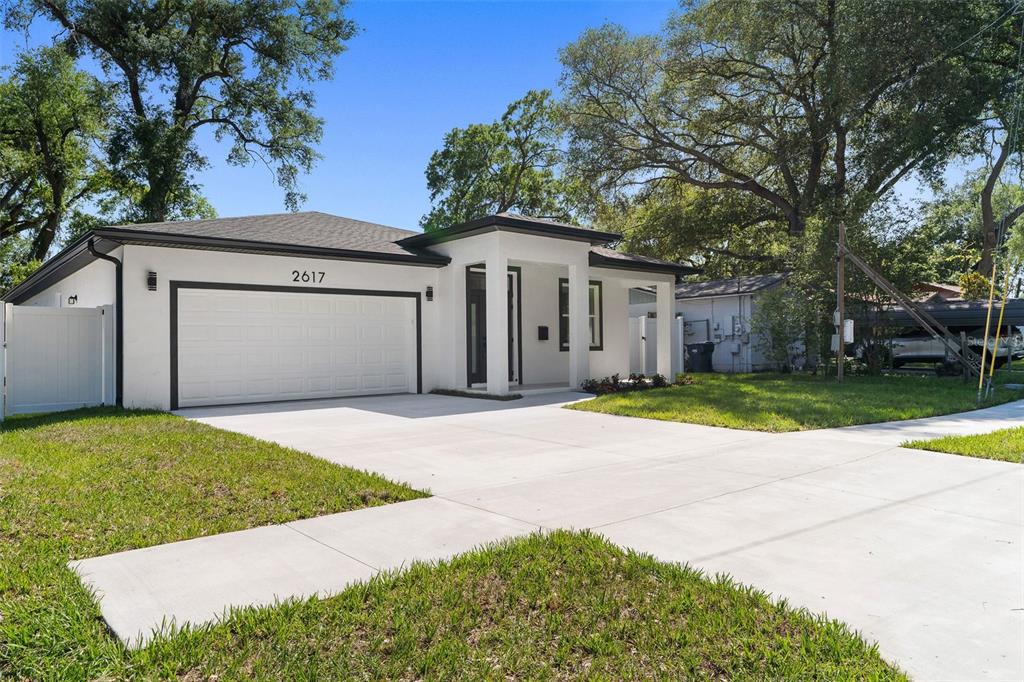A white single-story house with a two-car garage and a covered front entryway — 2617 E PALIFOX STREET, TAMPA, FL