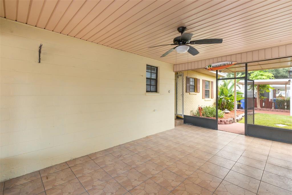 A covered patio features a tiled floor, a ceiling fan, and a screen enclosure — 4506 24TH AVENUE S, TAMPA, FL