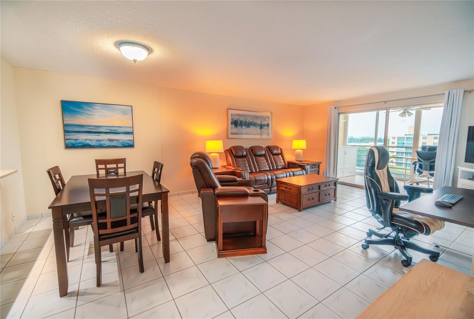A living and dining area with tile floors, leather furniture, and a balcony view — 131 SE 3rd Avenue # 608, Dania Beach FL 33004, DANIA BEACH, FL