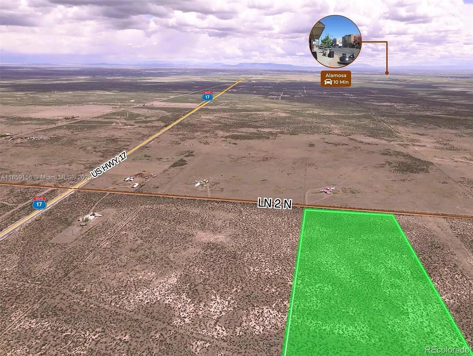 This aerial view shows a vacant, rectangular plot of land highlighted in green near a highway — 10 N 2 Lane, CO 81146, CO
