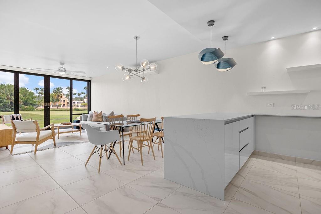 A modern open-concept kitchen and dining area with white marble floors and floor-to-ceiling windows — 310 BEACH VILLAGE DRIVE, HUMACAO, PR