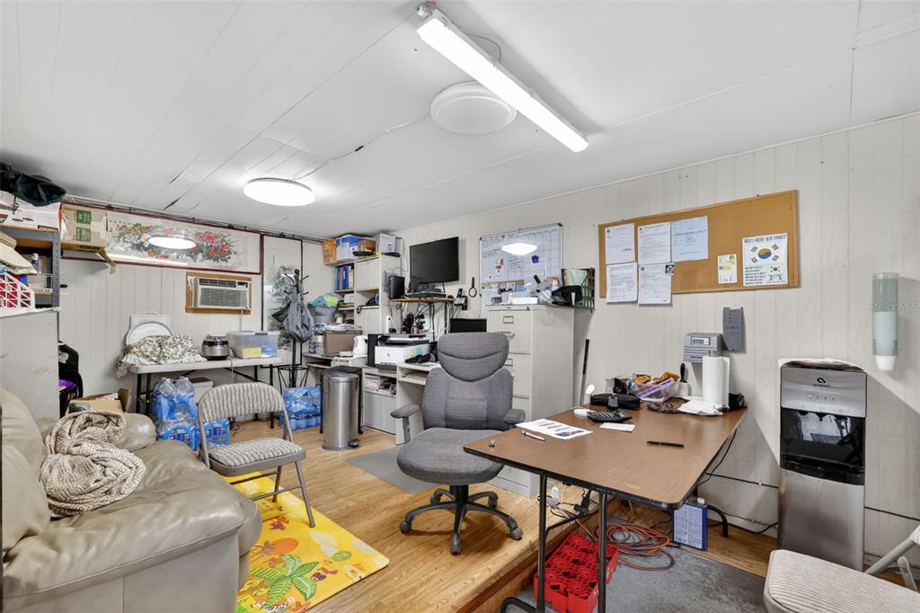 A cluttered home office features a desk, office chair, sofa, and various storage items — 2866 LENT ROAD, APOPKA, FL