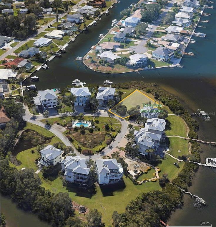 An aerial view shows a vacant waterfront lot highlighted in a residential community — 5523 2ND AVENUE CIRCLE W, PALMETTO, FL