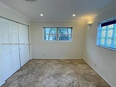 A room with white walls, a tiled floor, double closet doors, and a glass-block window — 1107 NE 8th St, Hallandale Beach FL 33009, HALLANDALE BEACH, FL