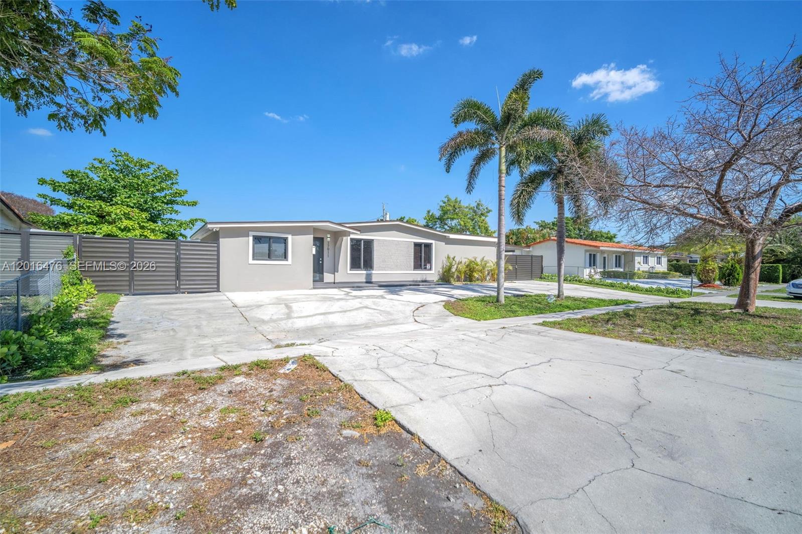 A single-story house with a large concrete driveway and two palm trees in the front — 17911 NW 82nd Ave, Hialeah FL 33015, HIALEAH, FL