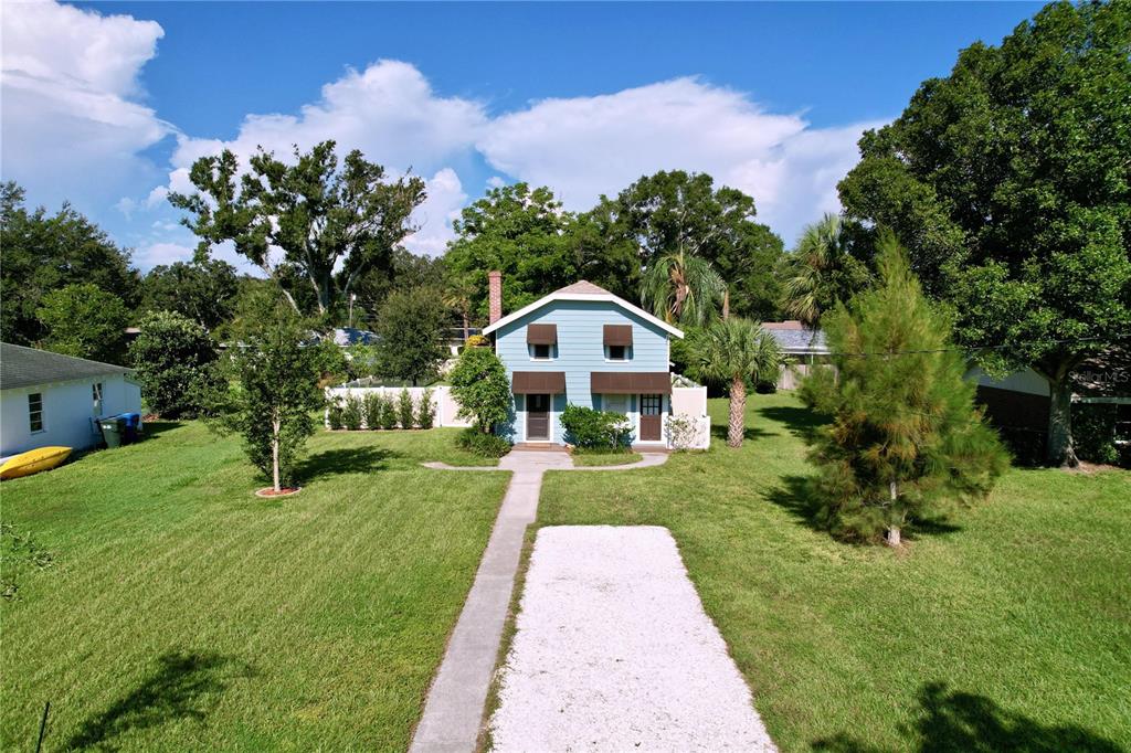 An aerial view of a light blue two-story house with a gravel driveway and lawn — 363 14TH STREET NW, LARGO, FL