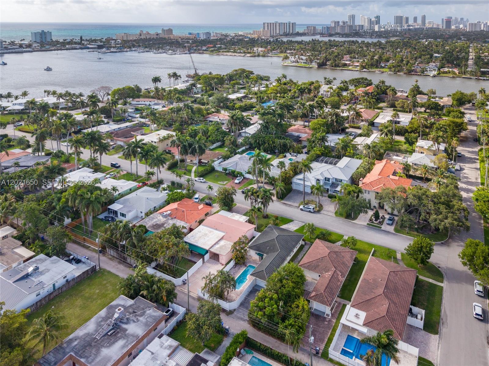 An aerial view shows a residential neighborhood with houses, swimming pools, and palm trees — 947 Lincoln St, Hollywood FL 33019, HOLLYWOOD, FL