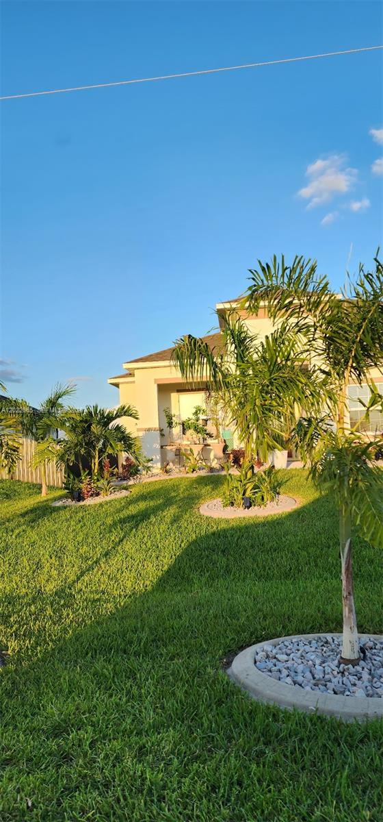 A single-story house exterior features a green lawn, palm trees, and a covered entryway — 225 SW 31ST PL, Cape Coral FL 33991, CAPE CORAL, FL