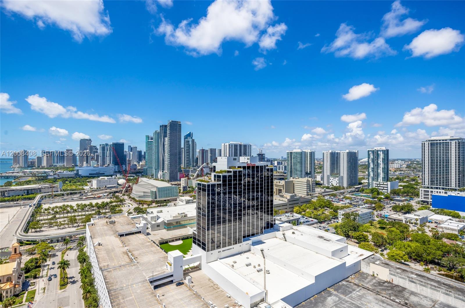 An aerial view shows a city skyline with a prominent dark glass hotel building — 1750 N Bayshore Dr # 3308, Miami FL 33132, MIAMI, FL