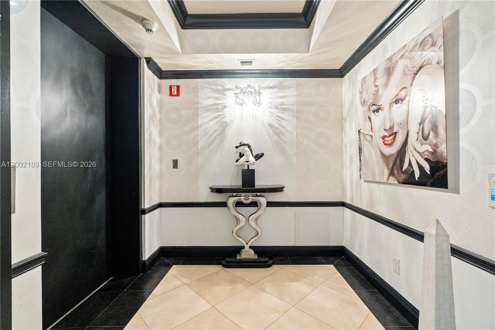 A foyer features a Marilyn Monroe portrait, a console table, and black and white trim — 21050 Point Pl # 403, Aventura FL 33180, AVENTURA, FL