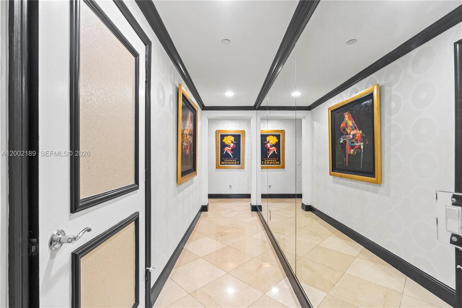 A hallway features tiled floors, patterned wallpaper, black trim, and framed artwork on the walls — 21050 Point Pl # 403, Aventura FL 33180, AVENTURA, FL