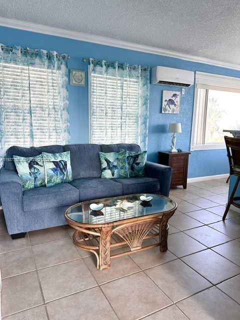 A living room features a blue sofa, a glass-topped rattan coffee table, and tiled floors — 3401 NE 10th St # 12, Pompano Beach FL 33062, POMPANO BEACH, FL