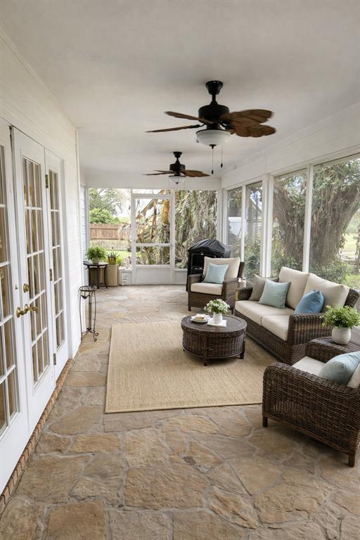 A screened-in porch features stone flooring, wicker furniture, and two ceiling fans — 14747 GREEN VALLEY BOULEVARD, CLERMONT, FL