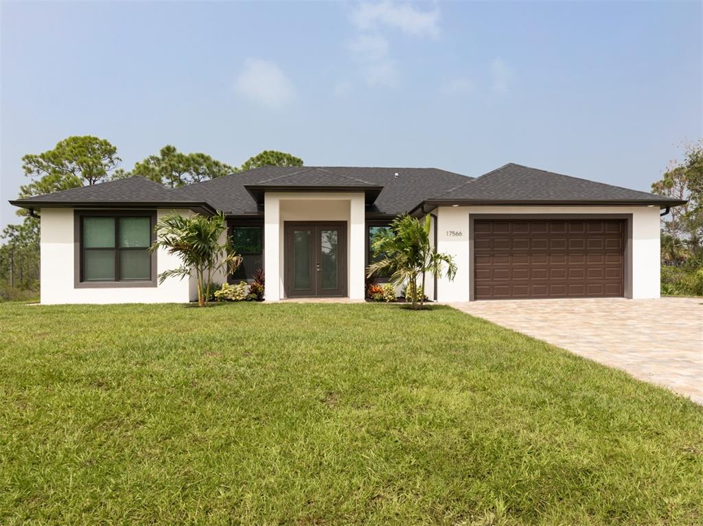 A single-story house with a white exterior, dark roof, and a two-car garage — 17566 DE MIRANDA AVENUE, NORTH PORT, FL