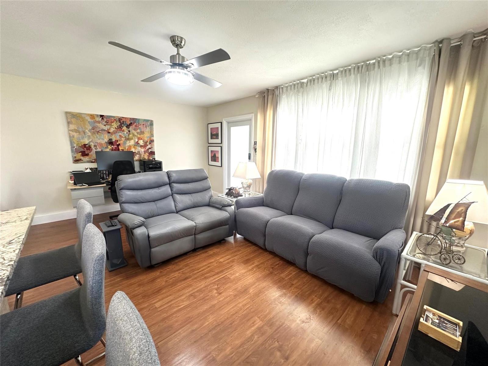 A living room features two gray sofas, a ceiling fan, and wood-look flooring — 528 Tilford X # 528, Deerfield Beach FL 33442, DEERFIELD BEACH, FL