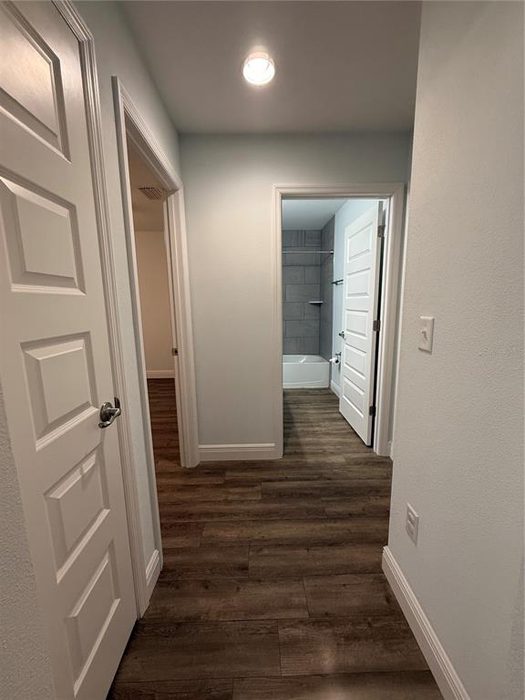 A hallway with wood-look flooring leads to a bathroom with a tiled tub surround — 7752 N WALTON TERRACE, CITRUS SPRINGS, FL