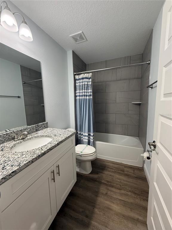 A bathroom features a granite-topped vanity, a toilet, and a tub with gray tiled walls — 7752 N WALTON TERRACE, CITRUS SPRINGS, FL