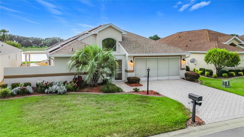 A single-story house with a paved driveway, a two-car garage, and a front lawn — 11363 SE 177TH LANE, SUMMERFIELD, FL