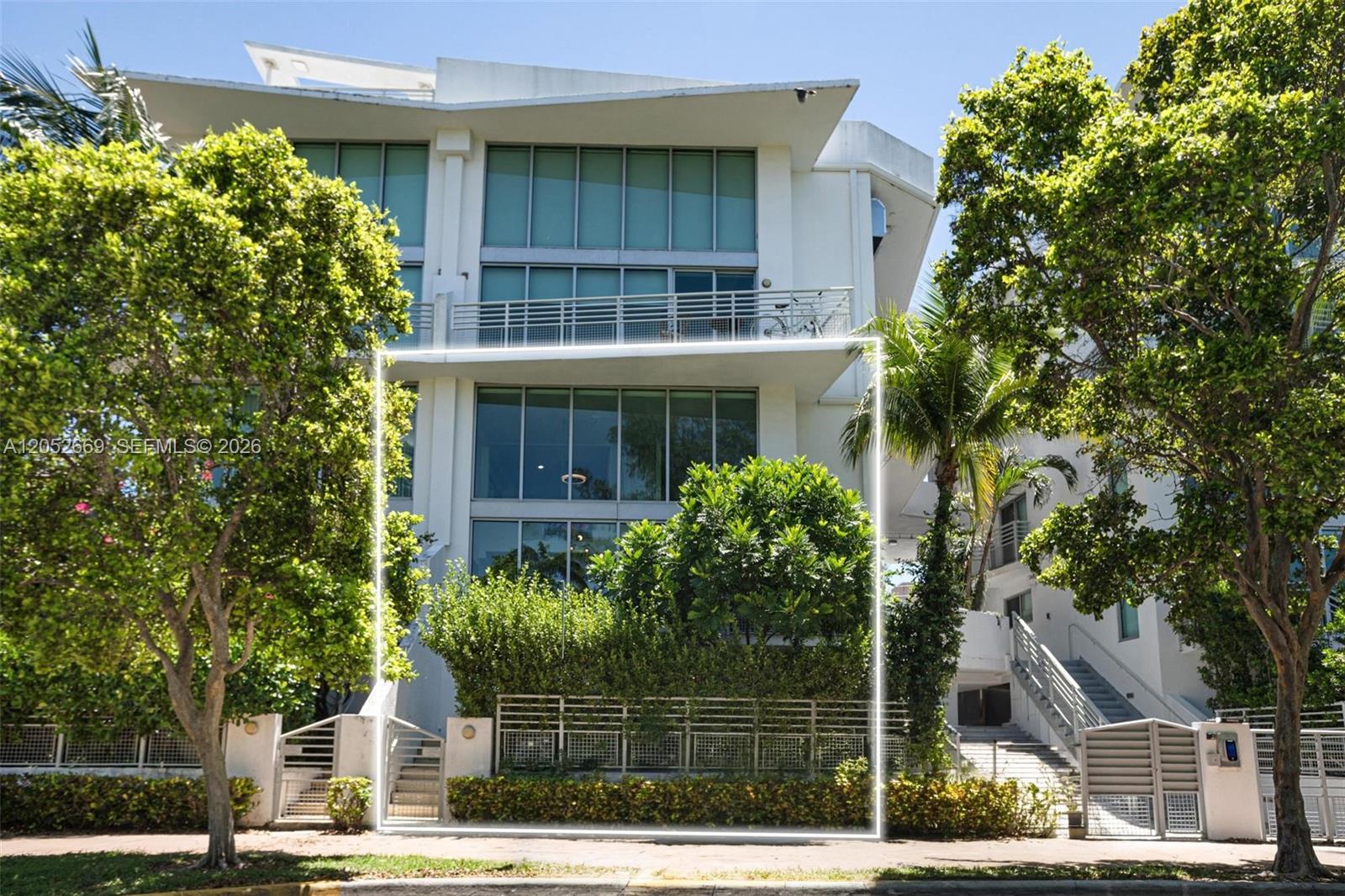 A multi-story white residential building features large glass windows and a fenced front garden — 245 Michigan Ave # 5, Miami Beach FL 33139, MIAMI BEACH, FL