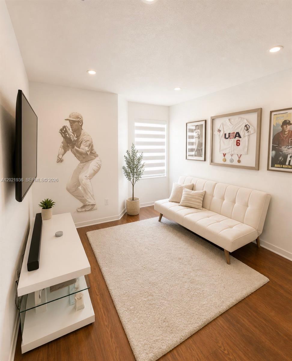 A small room features a white futon, a wall-mounted television, and baseball-themed wall decor — 16342 SW 45th Ter, Miami FL 33185, MIAMI, FL