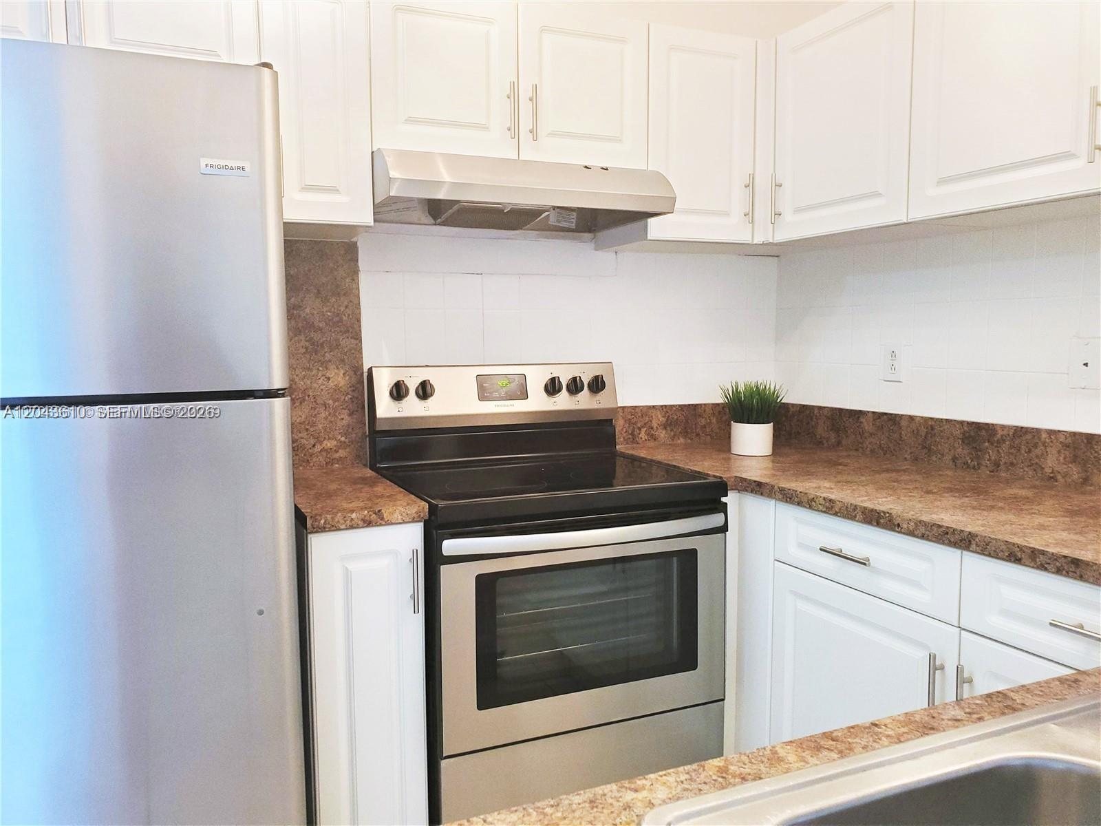 A kitchen features white cabinets, stainless steel appliances, and brown laminate countertops — 15659 SW 73rd Cir Ter # 4, Miami FL 33193, MIAMI, FL