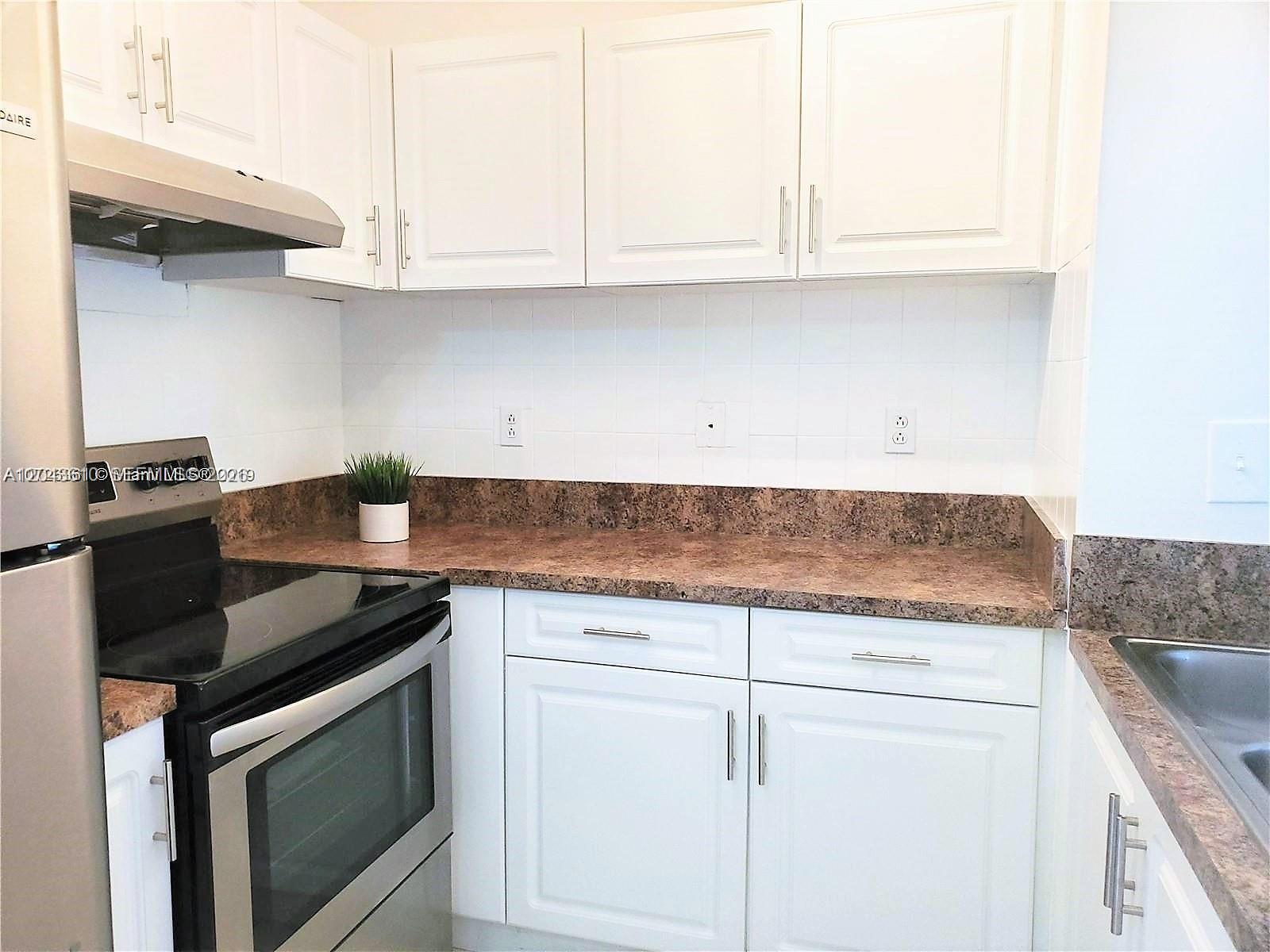 A kitchen features white cabinets, a brown laminate countertop, and stainless steel appliances — 15659 SW 73rd Cir Ter # 4, Miami FL 33193, MIAMI, FL
