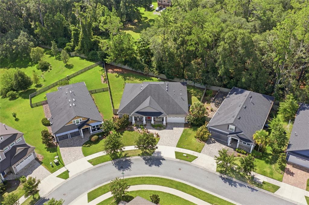 An aerial view shows three suburban houses with gray roofs and paved driveways on a cul-de-sac — 13417 NW 10TH LANE, NEWBERRY, FL