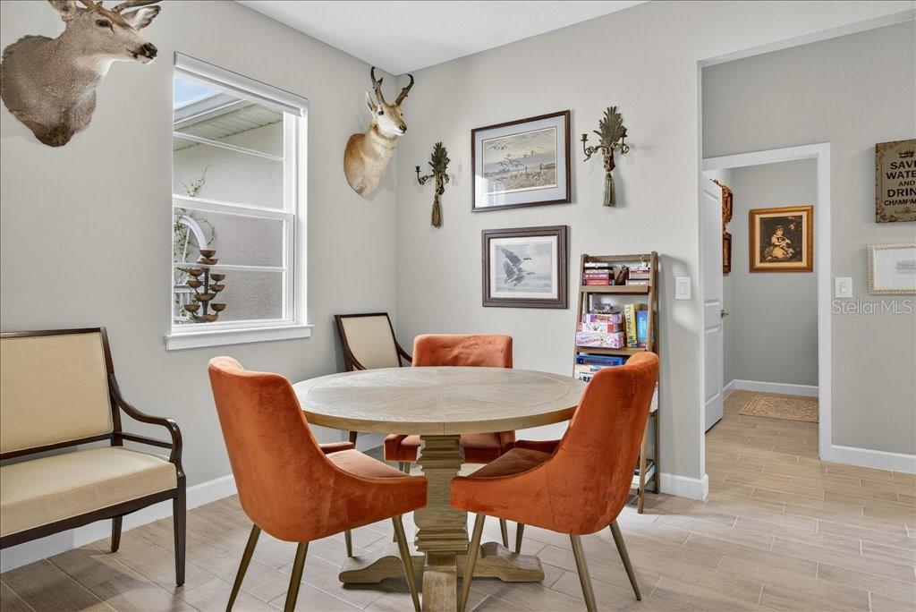 A living area features two white armchairs, a wooden ladder shelf, and wall-mounted decor — 44 BOULDER ROCK DRIVE, PALM COAST, FL