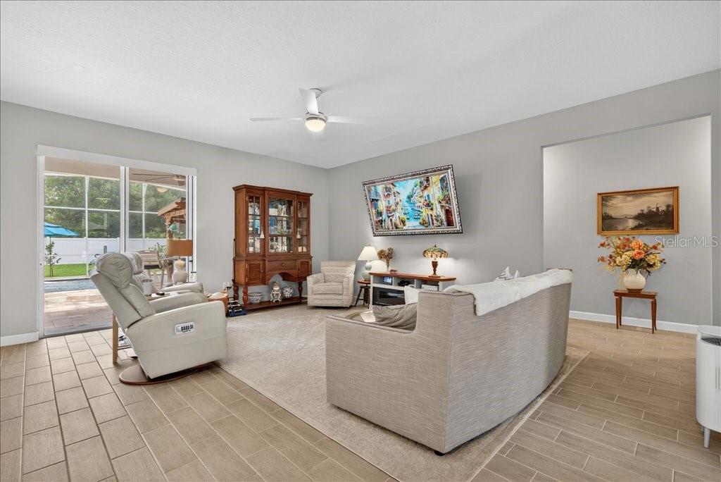 A hallway features a textured wooden sideboard, a table lamp, wall art, and a floor vase — 44 BOULDER ROCK DRIVE, PALM COAST, FL