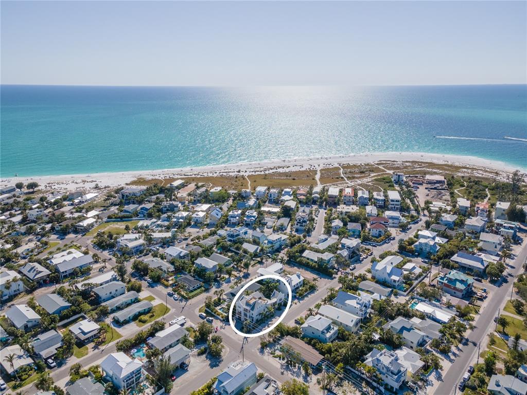 An aerial view shows a coastal neighborhood with a white-circled house near the beach — 416 ALAMANDA ROAD, ANNA MARIA, FL