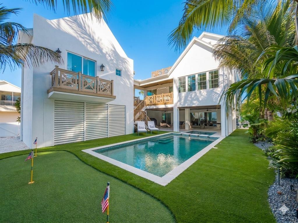 A white two-story house with a swimming pool, putting green, and wooden balconies — 416 ALAMANDA ROAD, ANNA MARIA, FL