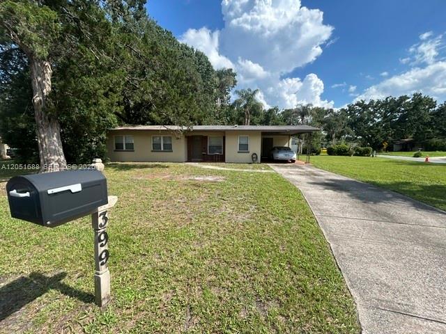 A single-story house with a carport and a mailbox in the foreground — 399 BETH DR, Sanford FL 32771, SANFORD, FL