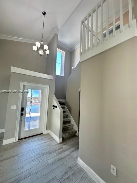 An entryway features a high ceiling, a chandelier, a staircase, and light-colored wood-look flooring — 19853 NW 64th Pl, Hialeah FL 33015, HIALEAH, FL