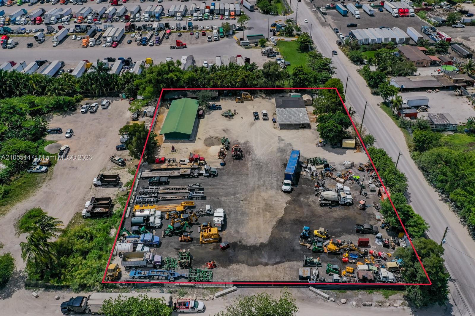 An aerial view shows a fenced industrial lot containing two buildings, trucks, and heavy equipment — 15721 NW 122 AVE, Miami FL 33018, MIAMI, FL