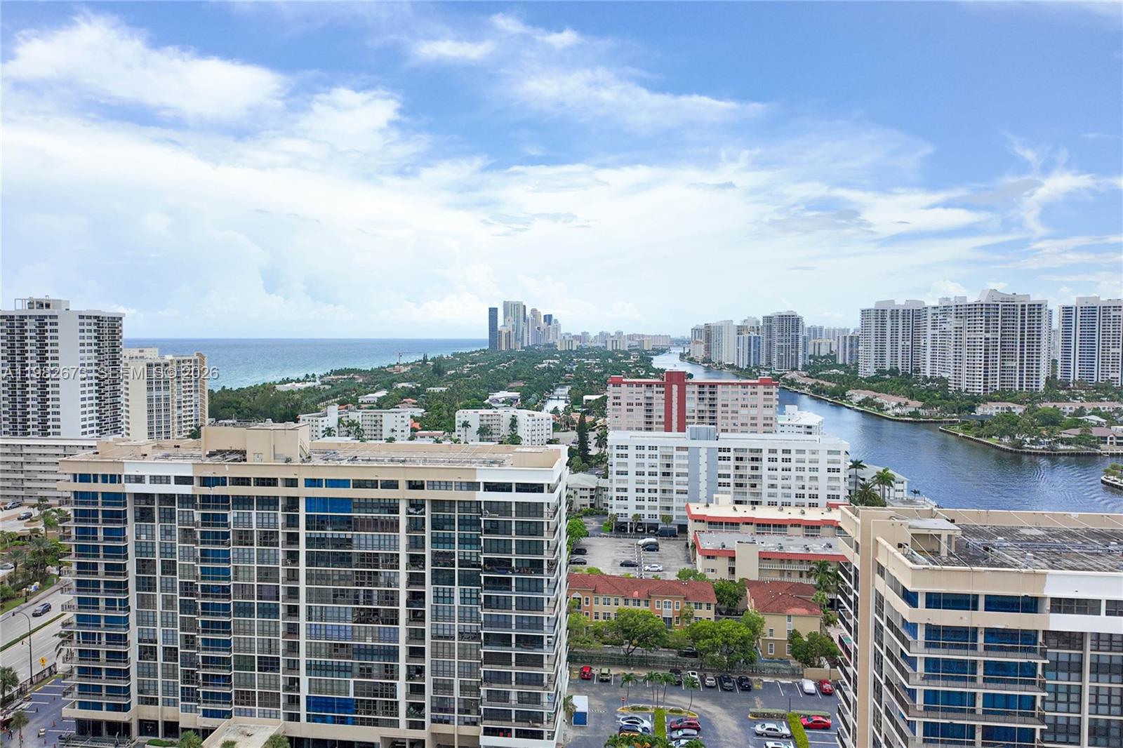 An elevated view shows high-rise apartment buildings, a waterway, and the ocean in the distance — 1985 S Ocean Dr # 22E, Hallandale Beach FL 33009, HALLANDALE BEACH, FL