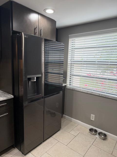A modern kitchen features a dark stainless steel LG refrigerator, gray cabinets, and tile flooring — 99 Capri C # 99, Delray Beach FL 33484, DELRAY BEACH, FL