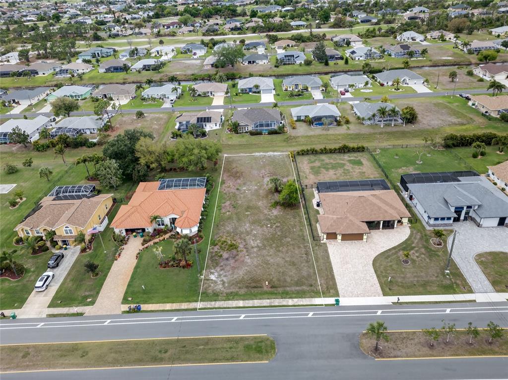An aerial view shows a vacant residential lot situated between two houses with swimming pools — 211 ROTONDA BOULEVARD N, ROTONDA WEST, FL