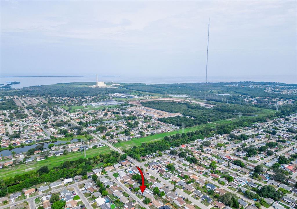 An aerial view shows a residential neighborhood with a red arrow pointing to a house — 3049 KILBURN ROAD, HOLIDAY, FL