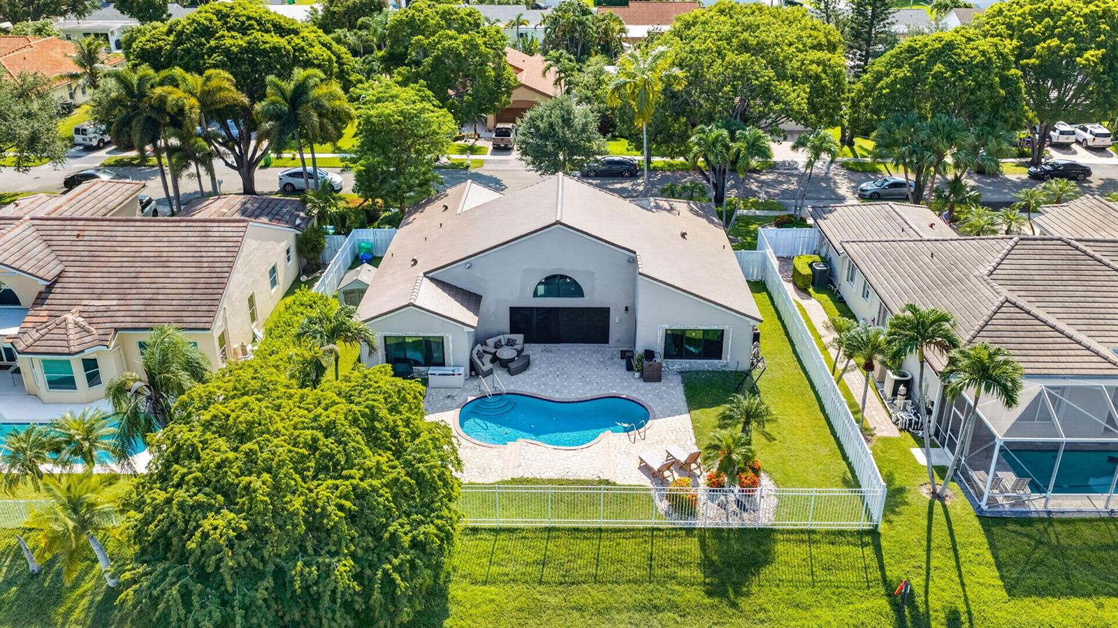 An aerial view shows a house with a backyard pool, patio, and white perimeter fence — 912 NW 132nd Avenue, Sunrise FL 33325, SUNRISE, FL