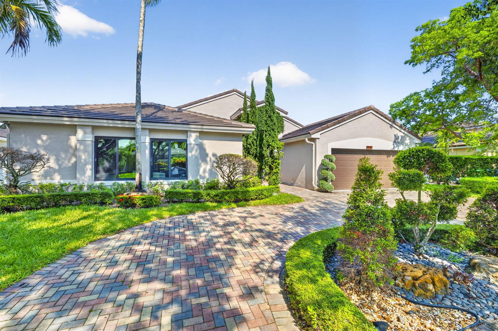 A single-story house with a brick paver driveway, a two-car garage, and manicured landscaping — 912 NW 132nd Avenue, Sunrise FL 33325, SUNRISE, FL