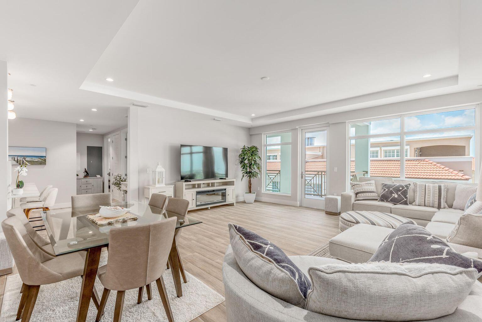 A bright open-concept living and dining area with light wood floors and large windows — 41 SW Seminole Street # 410, Stuart FL 34994, STUART, FL